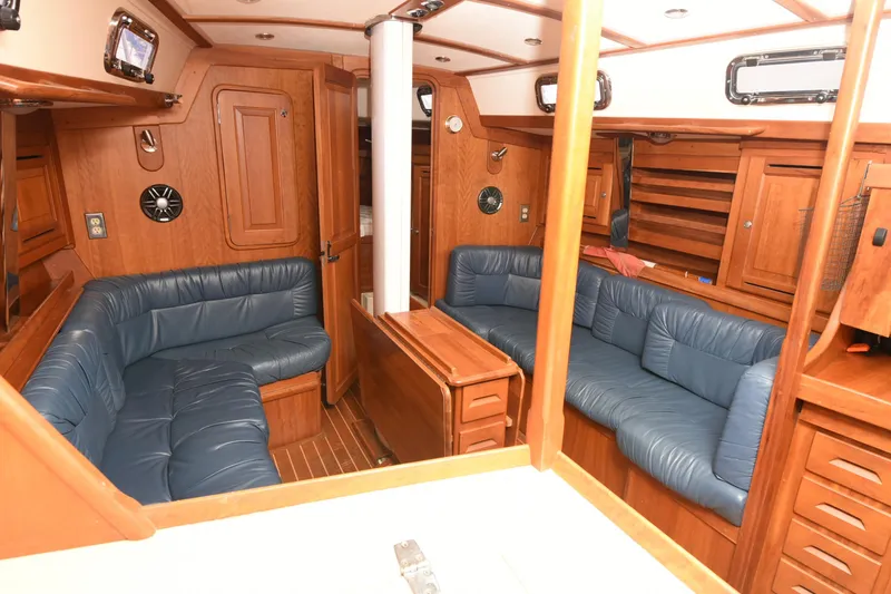 Makasi Yacht Photos Pics Luxurious 2008 Tartan 4100 yacht interior with blue leather seating and wooden cabinetry.