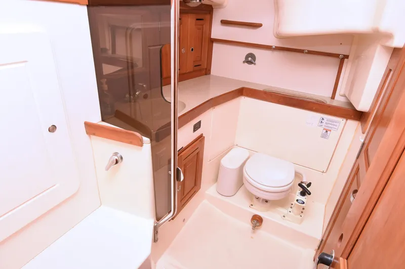 Makasi Yacht Photos Pics 2008 Tartan 4100 yacht bathroom with wooden cabinetry and compact toilet.