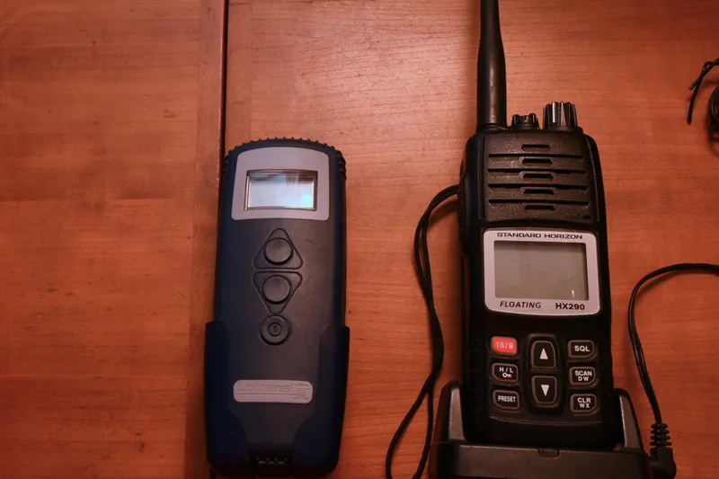 Makasi Yacht Photos Pics Two handheld devices on a wooden surface, including a Standard Horizon radio.