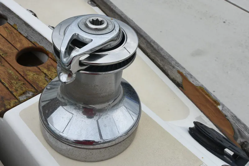 Makasi Yacht Photos Pics Chrome winch on 2008 Tartan 4100 sailboat deck, featuring weathered wood accents.