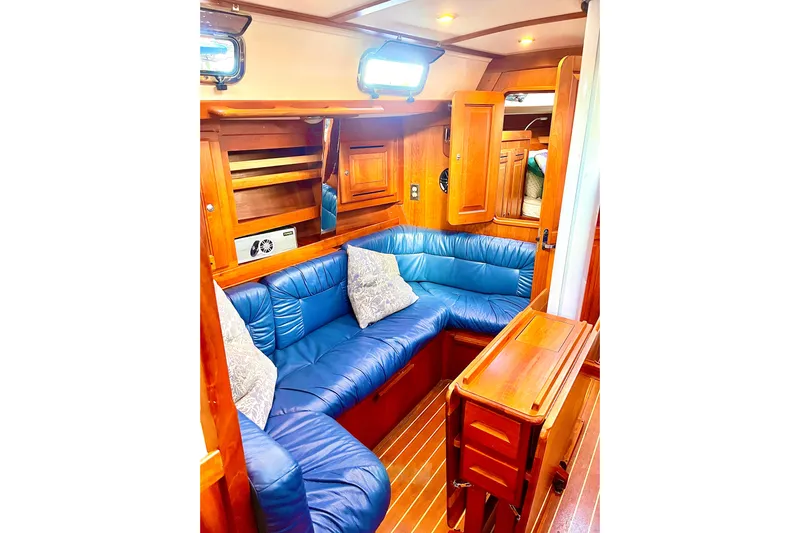 Makasi Yacht Photos Pics Luxurious 2008 Tartan 4100 yacht interior with blue leather seating and wooden accents.