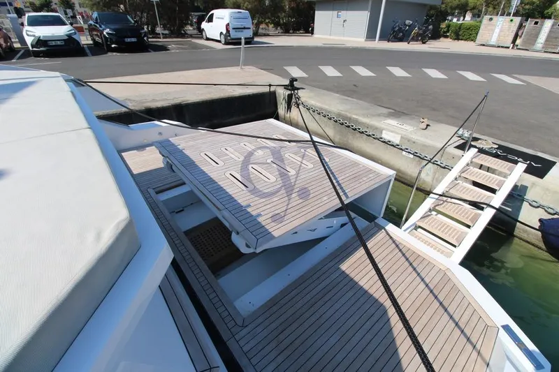 L Yacht Photos Pics 2024 Arcadia Yachts Sherpa 80XL docked, featuring a sleek wooden deck and modern design.