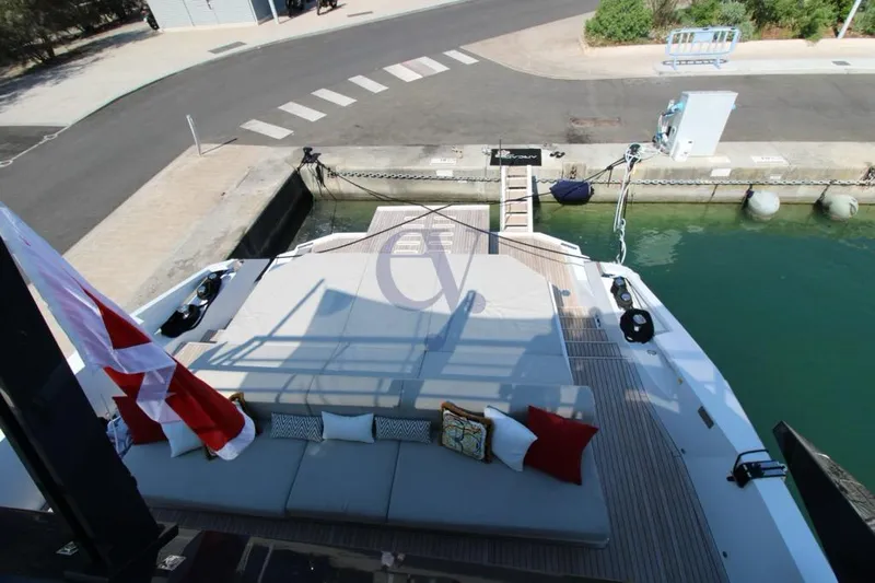 L Yacht Photos Pics 2024 Arcadia Yachts Sherpa 80XL docked, featuring spacious deck with seating and decorative pillows.