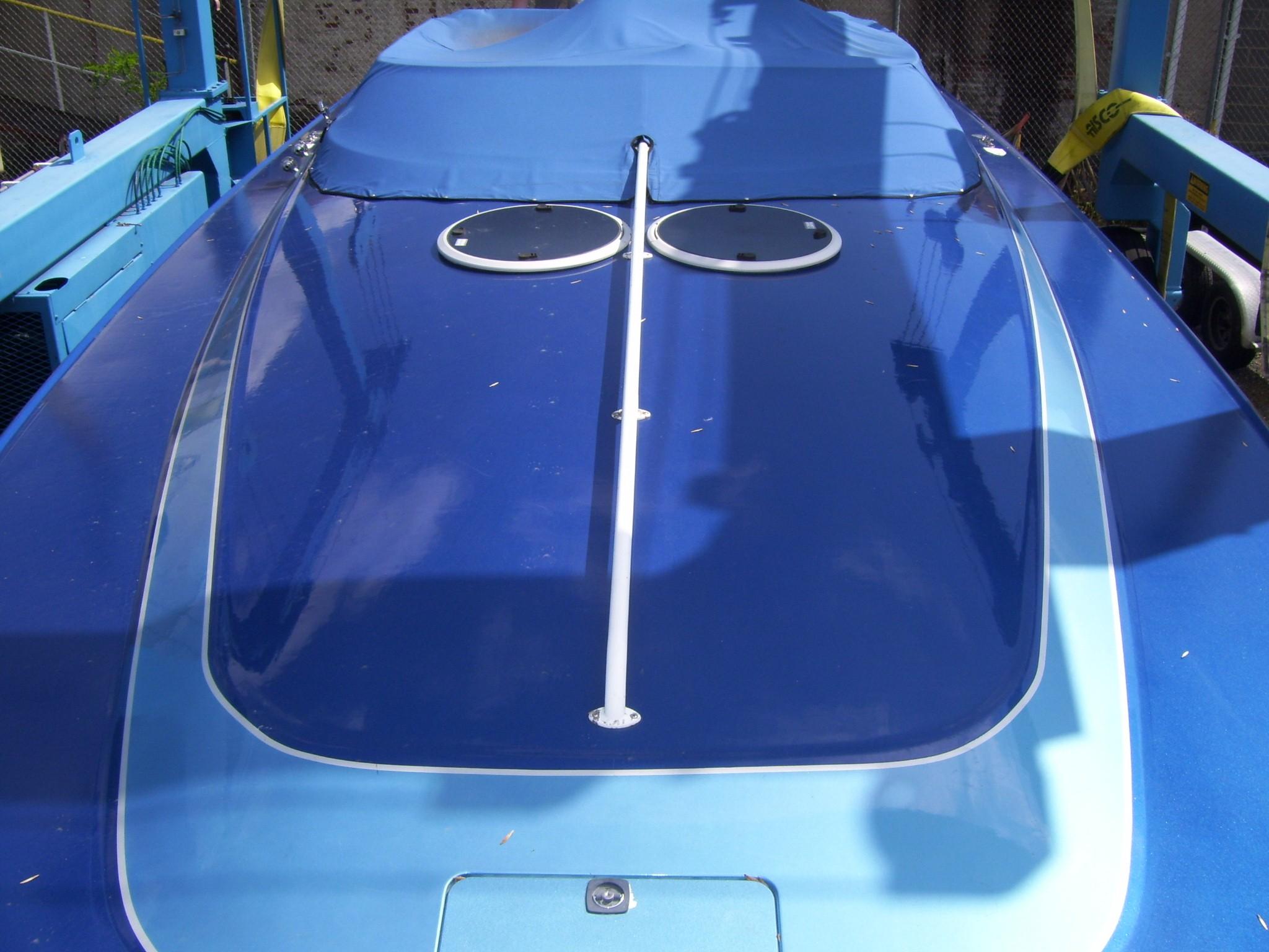 2002 Mares 38 High Performance boat with blue cover, docked and ready for use.