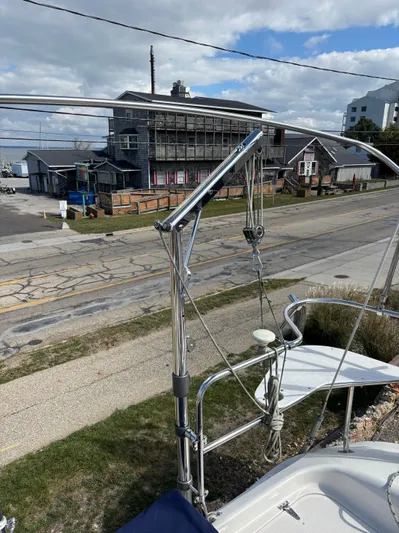Renaissance Yacht Photos Pics Catalina 380 sailboat docked near a rustic building, showcasing its stainless steel rigging.