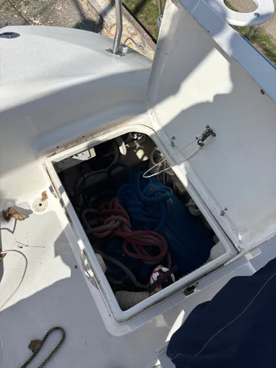 Renaissance Yacht Photos Pics Open hatch on 2000 Catalina 380 sailboat, revealing storage with ropes and equipment.