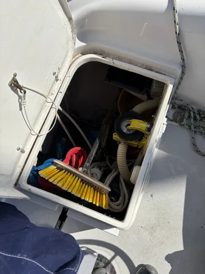 Renaissance Yacht Photos Pics Open storage compartment on 2000 Catalina 380 sailboat with ropes and cleaning supplies.