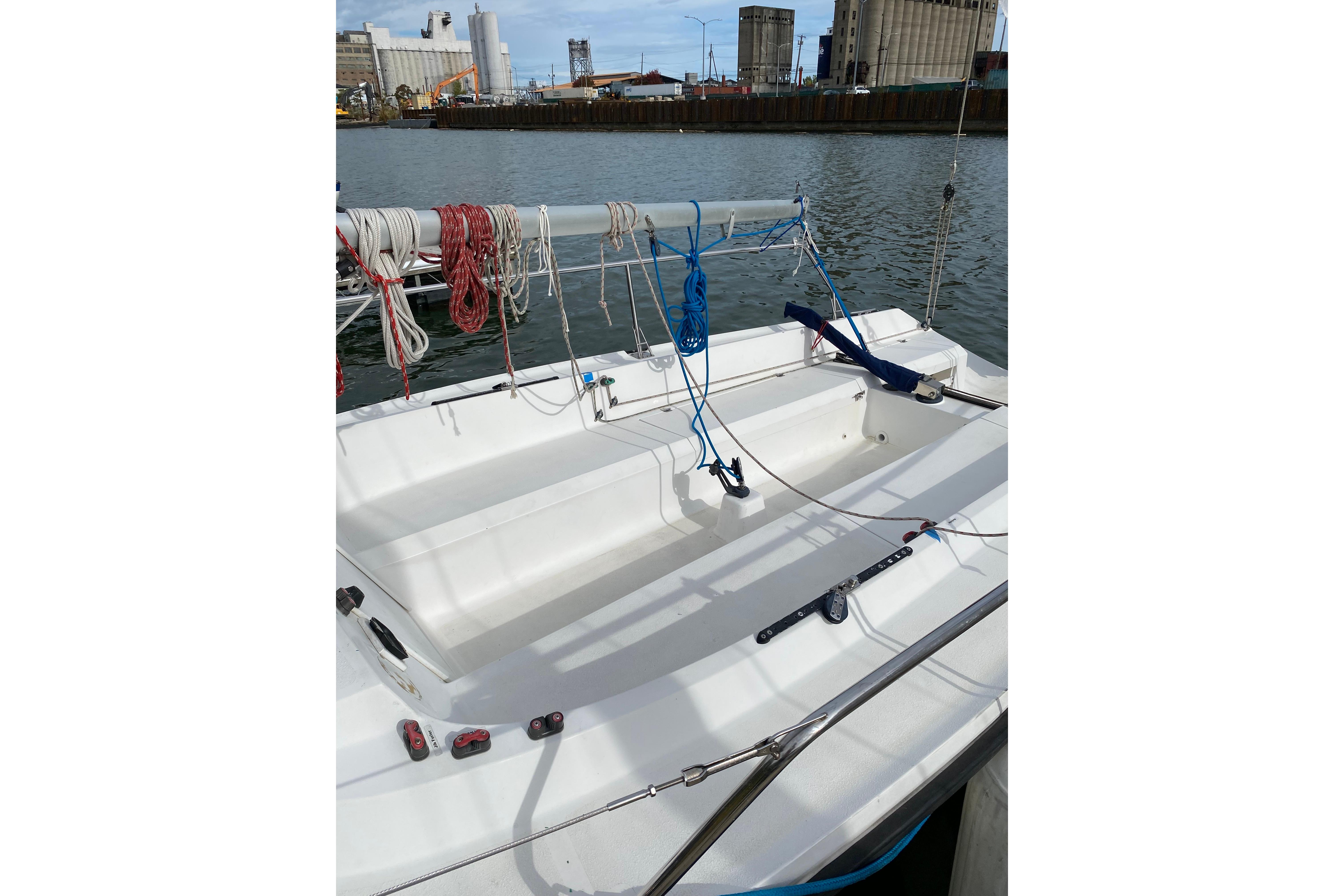 Sailboat cockpit with ropes, Colgate 26, 2004 model, docked in an industrial harbor.