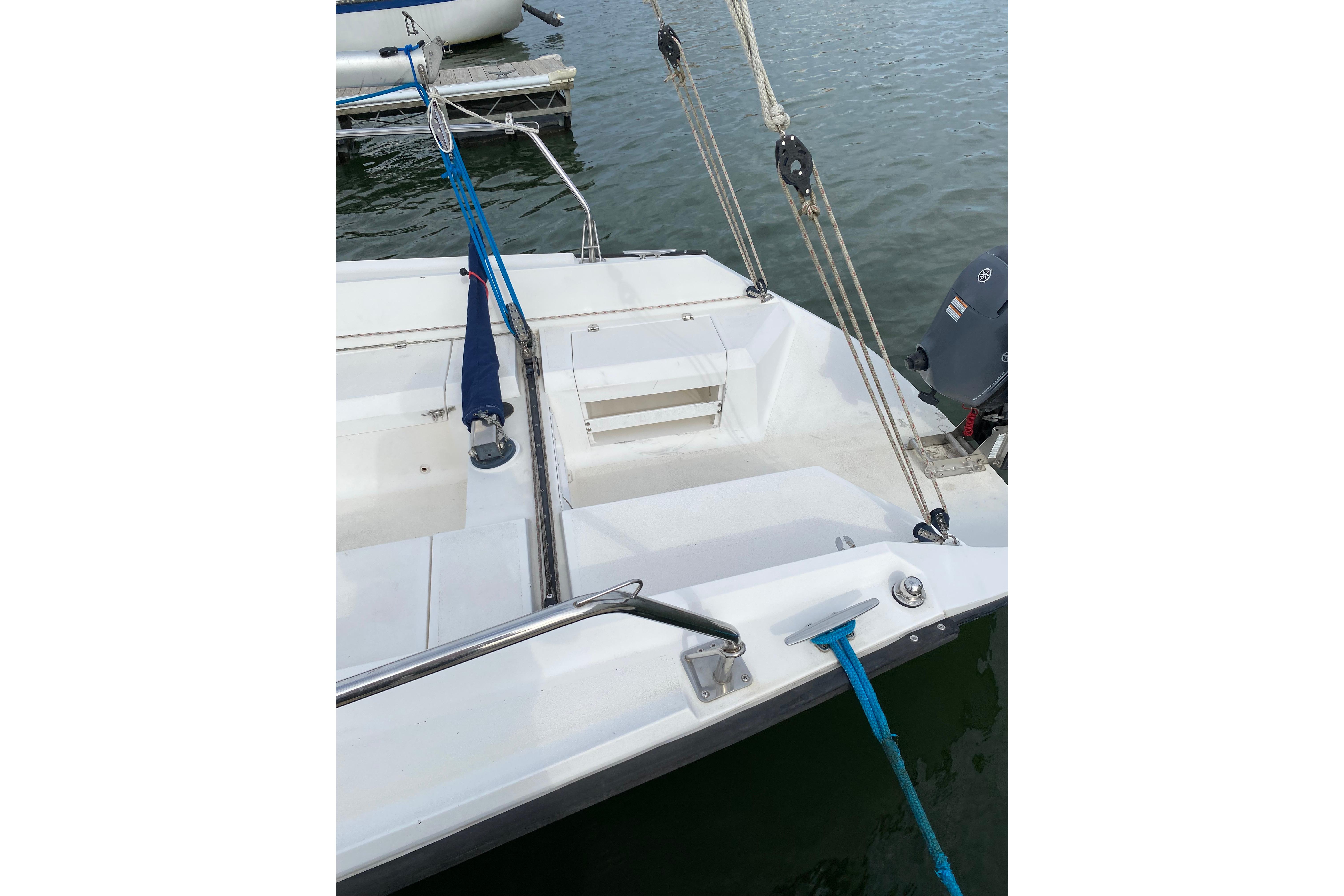 Sailboat deck view, Colgate 26, 2004 model, docked with visible ropes and motor.