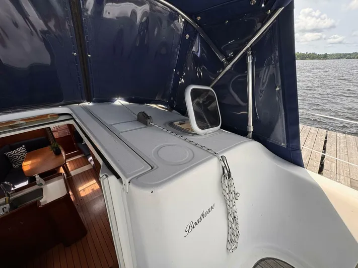  Yacht Photos Pics 2006 Beneteau 373 sailboat interior with wooden flooring and blue canopy, docked by the water.