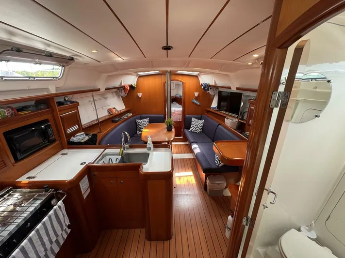  Yacht Photos Pics Interior of 2006 Beneteau 373 sailboat with kitchen, seating area, and wooden flooring.