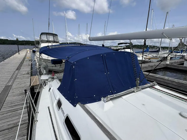  Yacht Photos Pics 2006 Beneteau 373 sailboat docked with blue canopy, clear sky background.