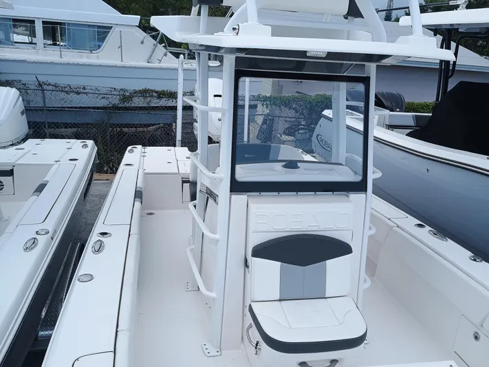 266-105 Yacht Photos Pics 2023 Robalo 266 Cayman SD boat with center console and seating, docked at marina.