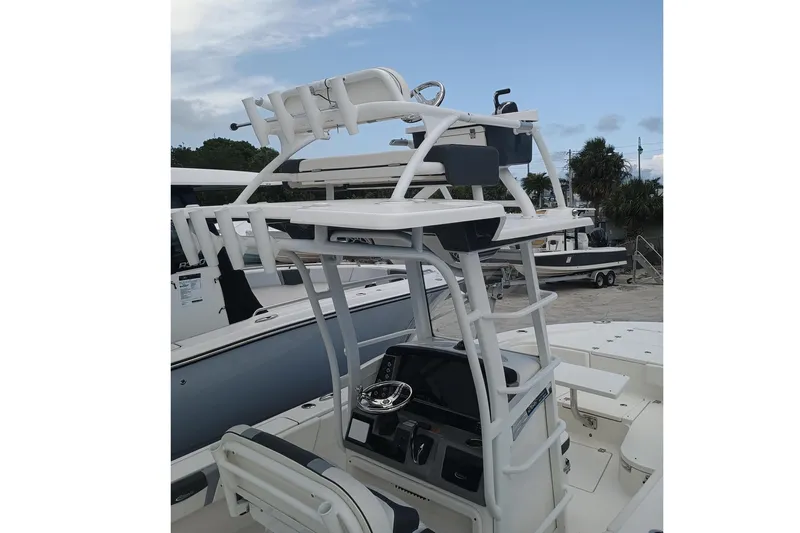 266-105 Yacht Photos Pics 2023 Robalo 266 Cayman SD boat with elevated helm and seating, docked under a cloudy sky.