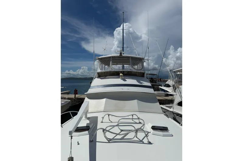 Marisabel Yacht Photos Pics 1984 Bertram 46 Convertible yacht docked under a partly cloudy sky.