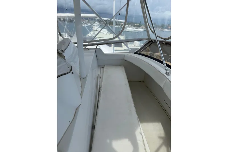 Marisabel Yacht Photos Pics 1984 Bertram 46 Convertible boat interior with seating and windows, showcasing nautical design.