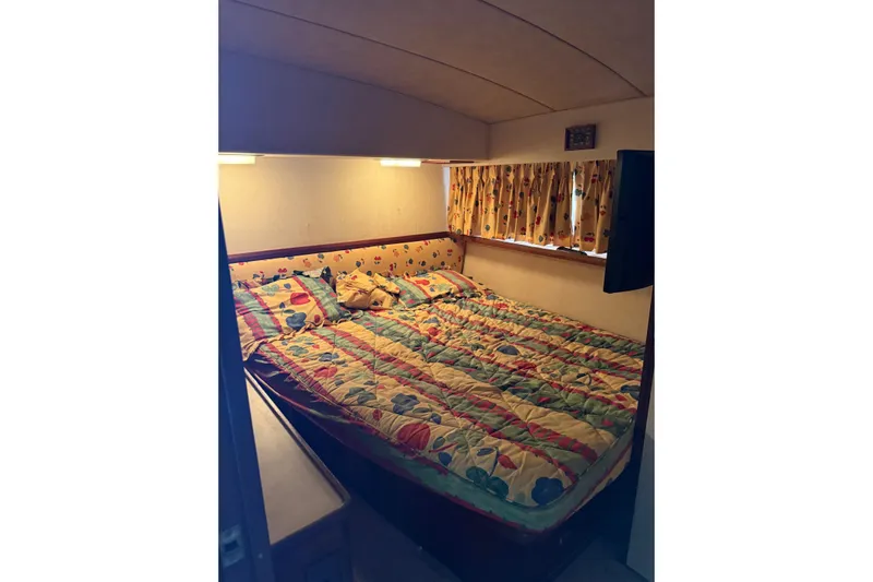 Marisabel Yacht Photos Pics Cozy bedroom in 1984 Bertram 46 Convertible yacht with colorful bedding and curtains.