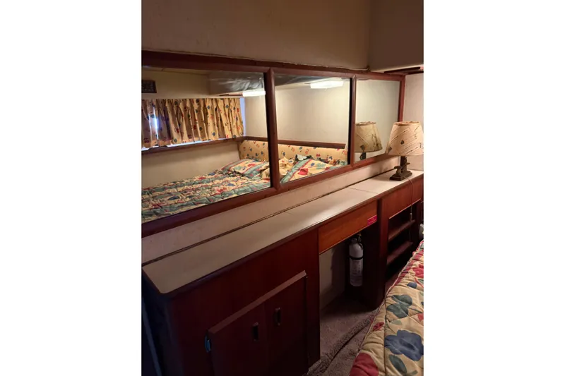 Marisabel Yacht Photos Pics Interior of 1984 Bertram 46 Convertible with mirror, bed, and wooden cabinetry.