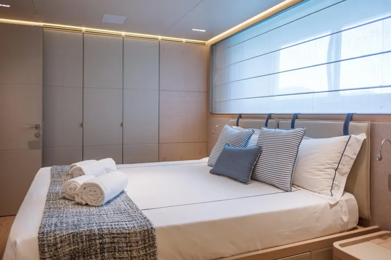 Tolemai Yacht Photos Pics Luxurious bedroom interior on 2023 Sanlorenzo XSP202 yacht with elegant bedding and soft lighting.