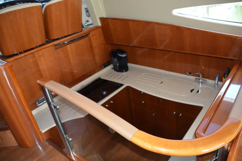 B&t Escape Yacht Photos Pics Luxurious kitchen area in a 2005 Princess 61 yacht with wooden cabinetry and modern appliances.