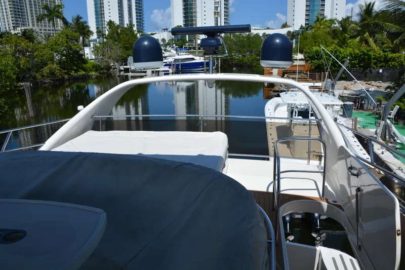 B&t Escape Yacht Photos Pics Luxury Princess 61 yacht deck, 2005 model, docked near waterfront buildings and lush greenery.