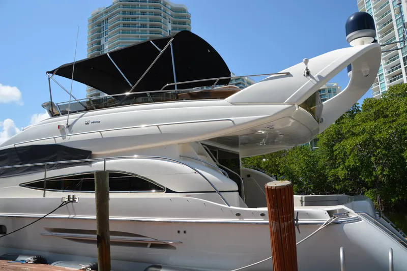 B&t Escape Yacht Photos Pics Luxury 2005 Princess 61 yacht docked near modern high-rise buildings.