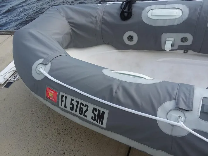 Bella Vita Yacht Photos Pics Gray inflatable boat with Florida registration FL 5762 SM, docked by the water.