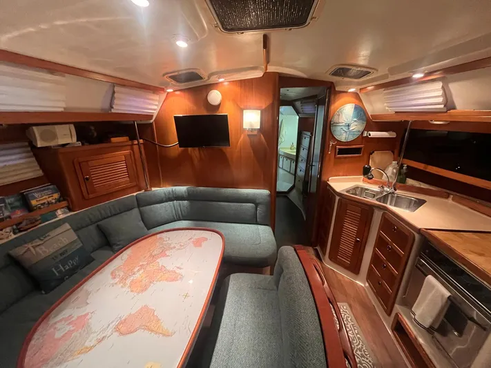 Bella Vita Yacht Photos Pics Interior of a 1999 Catalina 42 MkII sailboat with cozy seating and a map-themed table.