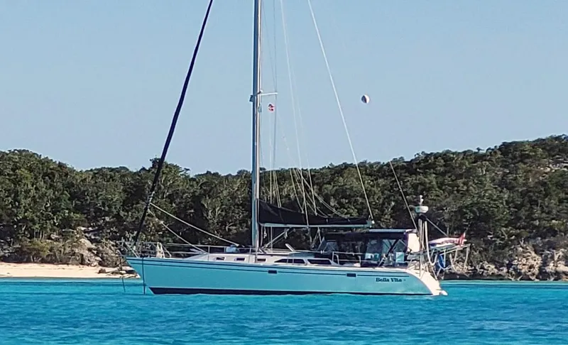 Bella Vita Yacht Photos Pics Sailboat Catalina 42 MkII 1999 anchored in clear blue water near a lush shoreline.
