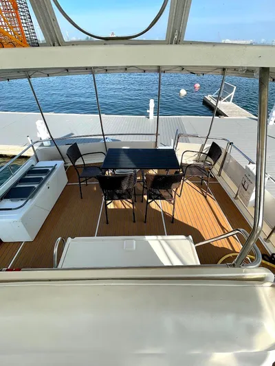  Yacht Photos Pics 1991 Hatteras 40 Motor Yacht deck with seating and table, docked by the water.