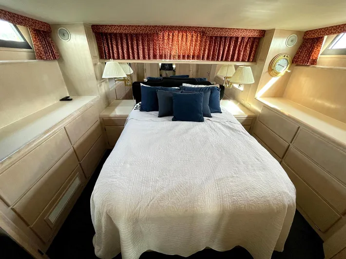  Yacht Photos Pics Interior of 1991 Hatteras 40 Motor Yacht bedroom with bed, lamps, and storage.