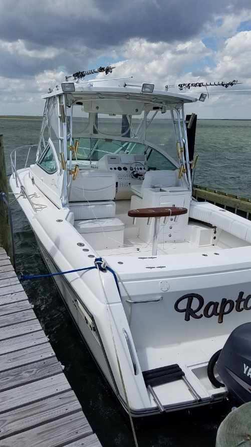 2004 Stamas 310 Express boat docked by the water under cloudy skies.