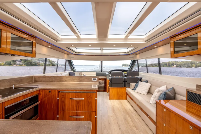 Change Happens Yacht Photos Pics Luxurious interior of 2017 Riviera 6000 Sport Yacht with panoramic windows and elegant wood finishes.