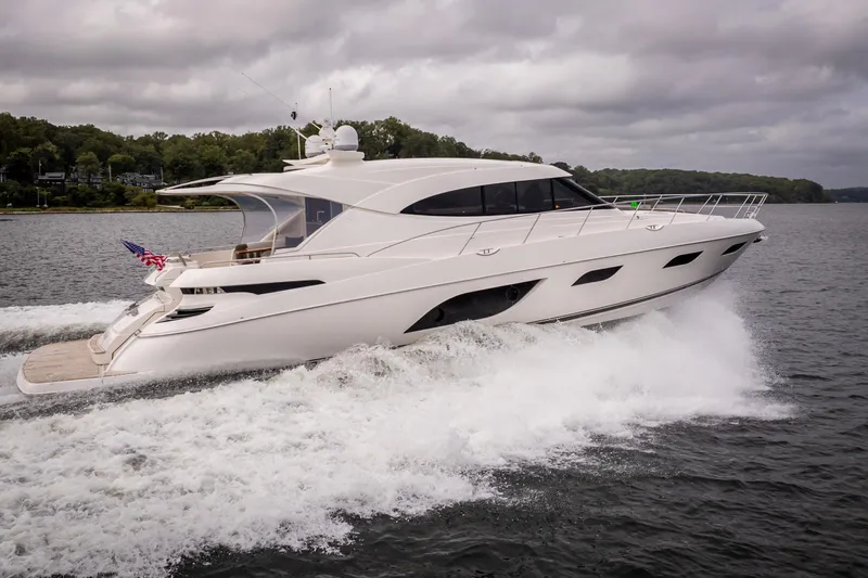 Change Happens Yacht Photos Pics 2017 Riviera 6000 Sport Yacht cruising on a lake under cloudy skies.