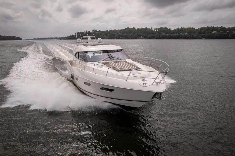 Change Happens Yacht Photos Pics 2017 Riviera 6000 Sport Yacht cruising on a lake under cloudy skies.