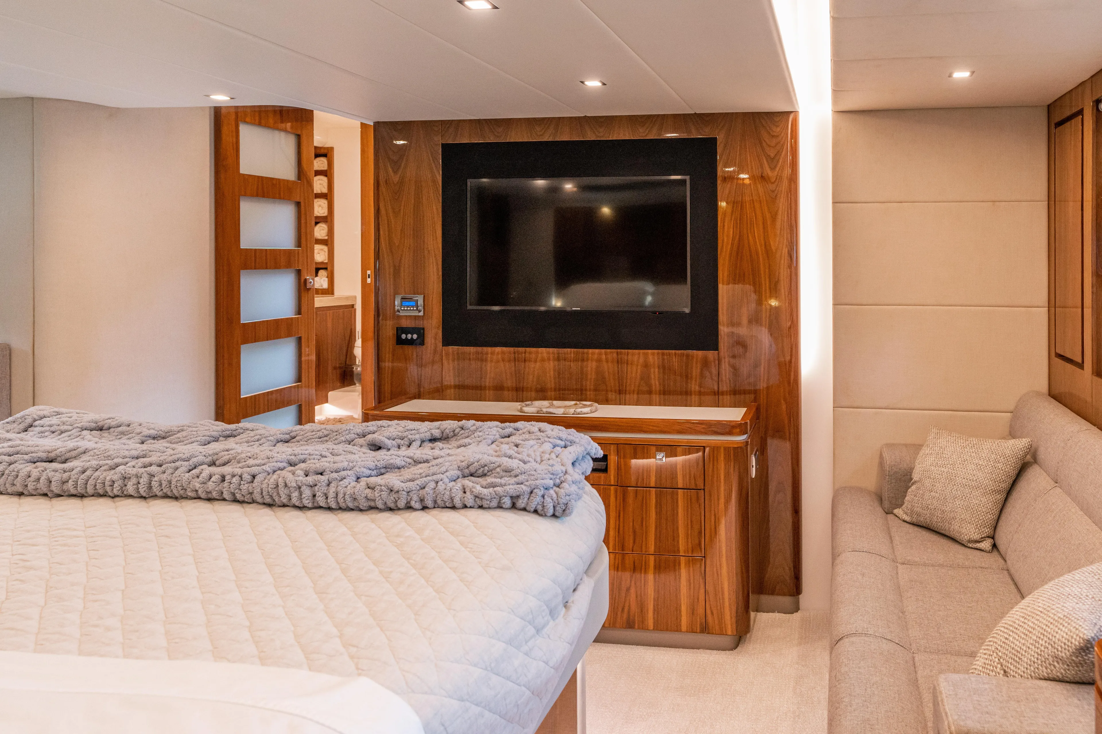 Change Happens Yacht Photos Pics Luxurious interior of 2017 Riviera 6000 Sport Yacht with TV, bed, and sofa.