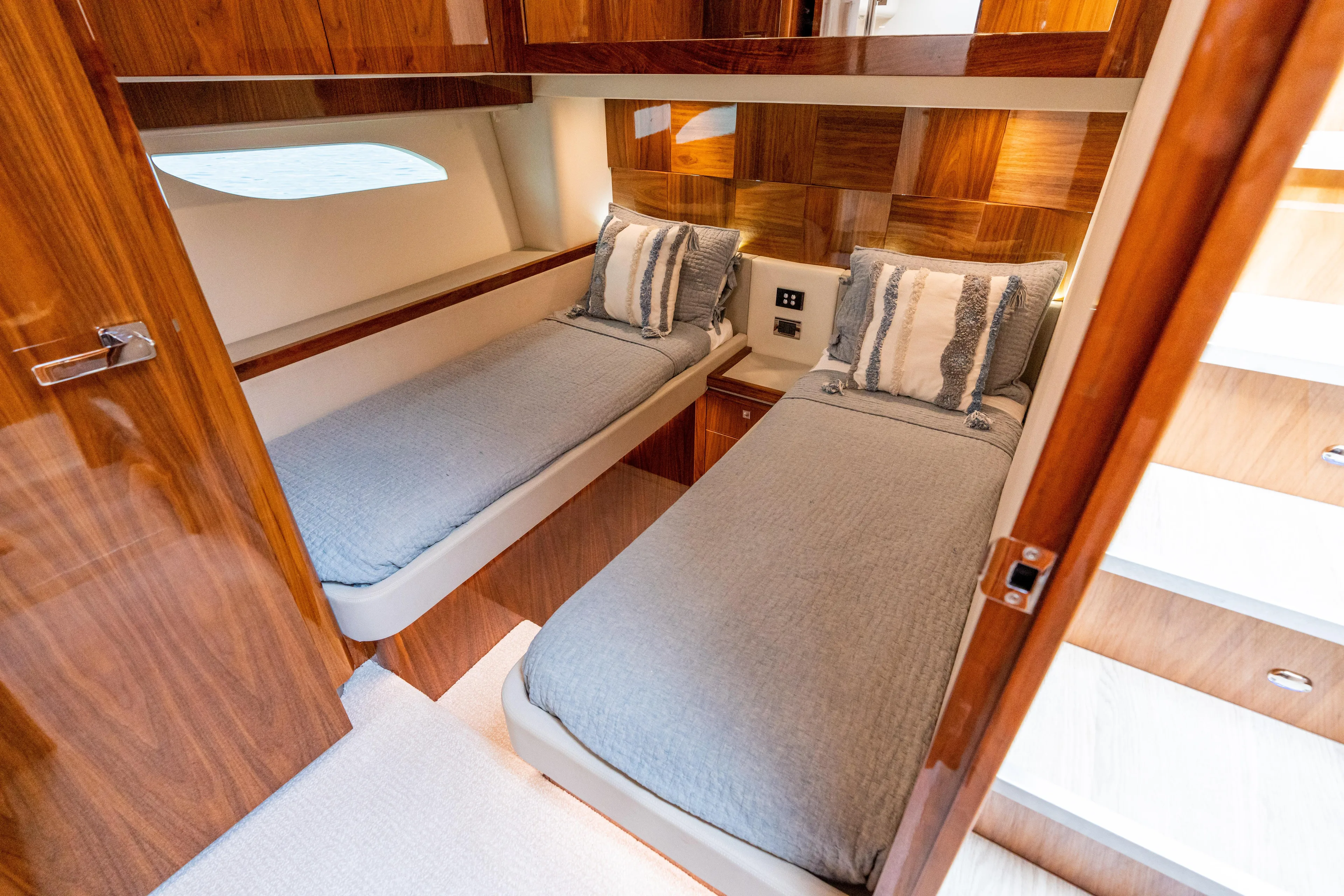 Change Happens Yacht Photos Pics 2017 Riviera 6000 Sport Yacht cabin with twin beds, wooden paneling, and modern decor.