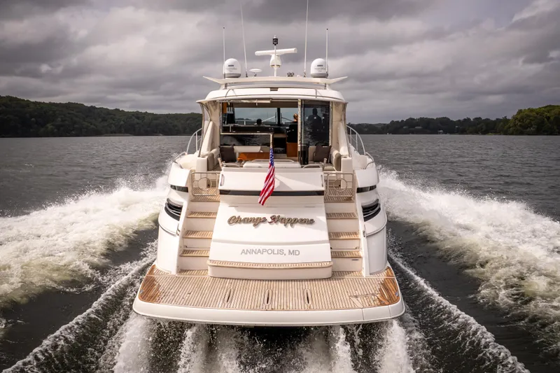 Change Happens Yacht Photos Pics 2017 Riviera 6000 Sport Yacht cruising on a lake, rear view with American flag.