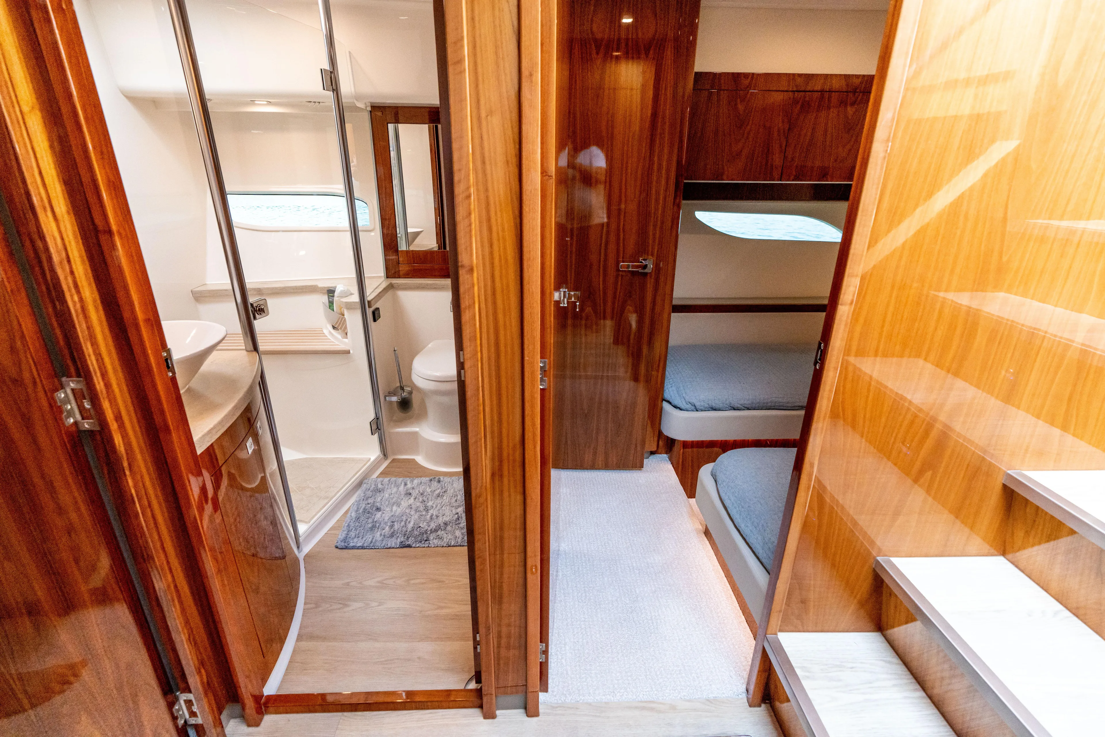 Change Happens Yacht Photos Pics 2017 Riviera 6000 Sport Yacht interior with wooden finishes, bathroom, and cozy sleeping area.