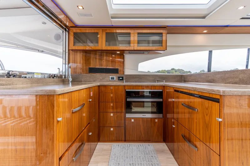 Change Happens Yacht Photos Pics Luxurious 2017 Riviera 6000 Sport Yacht kitchen with sleek wood cabinetry and modern appliances.