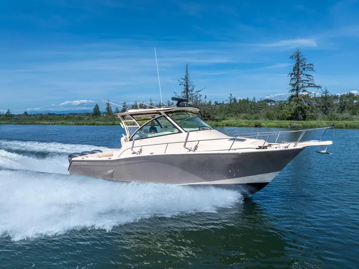  Yacht Photos Pics 2019 Grady-White Express boat cruising on a scenic lake under a clear blue sky.