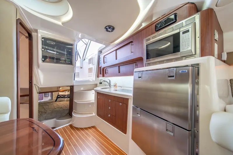  Yacht Photos Pics 2019 Grady-White Express boat interior with modern kitchen and wood accents.