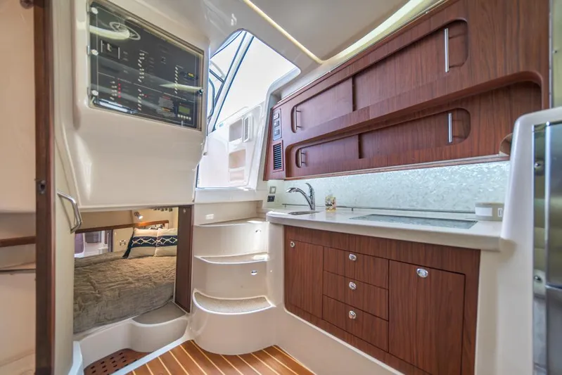  Yacht Photos Pics 2019 Grady-White Express boat interior with wood cabinetry and compact kitchen area.