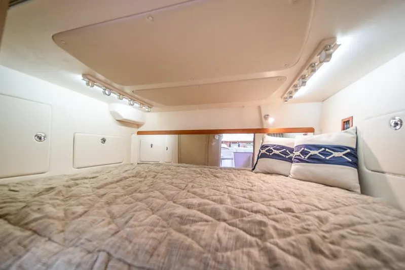  Yacht Photos Pics 2019 Grady-White Express cabin interior with cozy bedding and ambient lighting.