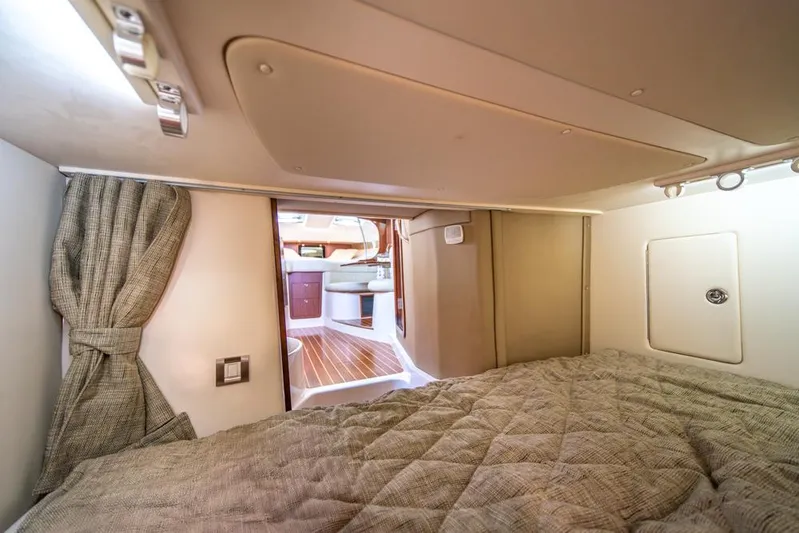  Yacht Photos Pics 2019 Grady-White Express cabin interior with bed, curtain, and wooden flooring.