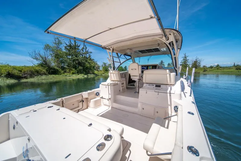  Yacht Photos Pics 2019 Grady-White Express boat on serene water, featuring spacious deck and canopy.