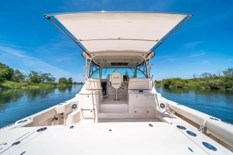  Yacht Photos Pics 2019 Grady-White Express boat on serene waterway under clear blue sky.