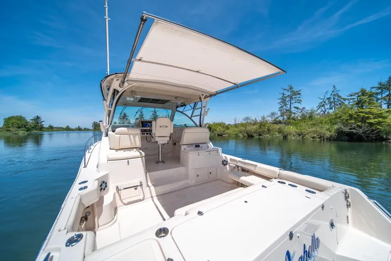  Yacht Photos Pics 2019 Grady-White Express boat on serene water, clear sky, lush greenery.