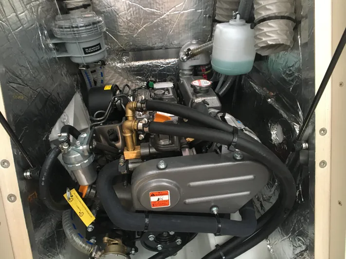  Yacht Photos Pics Engine compartment of 2024 Beneteau Oceanis 30.1 sailboat, showcasing mechanical components and hoses.