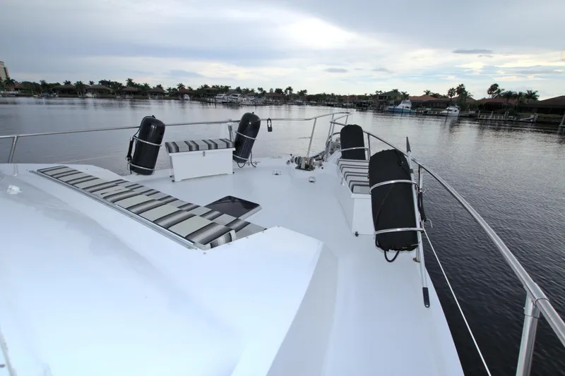 Cleodora Yacht Photos Pics 1988 Viking 63 Cockpit Motor Yacht deck with seating, docked on a calm waterway.